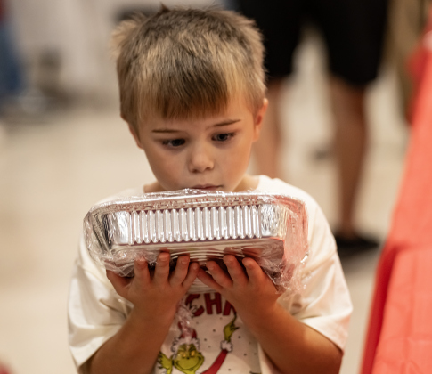 7-year-old Spencer Clayton admires homemade brownies his family was buying at the 22nd Annual  Come Home for Christmas Celebration held at St. John’s Methodist Church on Saturday, November 22, 2025. Spencer’s father is church pastor Rev. Dr. Roger Clayton, Jr.   The event included a Youth Cafe, with proceeds going to the St. John’s Youth Ministry.  There was also a silent auction, crafts made by church members, plus a bake sale.   Photo by Andy Sharp.