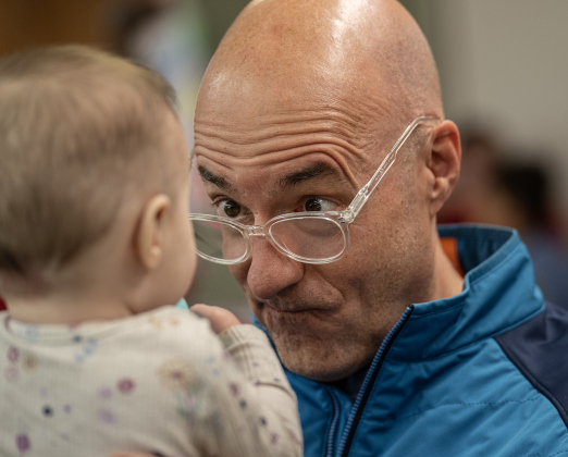Randy Bullard has fun spending time with his almost 7-month-old granddaughter Alice Wasson during  the 22nd Annual  Come Home for Christmas Celebration held at St. John’s Methodist Church on Saturday, November 22, 2025.  The event included a Youth Cafe, with proceeds going to the St. John’s Youth Ministry.  There was also a silent auction, crafts made by church members, plus a bake sale.   Photo by Andy Sharp.