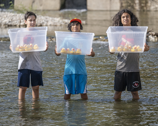 Jude Marquez, 12, left, Ari Felix, 11, center, and Ari’s brother Xavi, 13, right, prepare to send the ducks into the water for one o the championship heats during the 10th Annual AAUW Duck Race held on the river at San Gabriel Park on Saturday, November 1, 2025.  Rubber ducks are placed in the river and race to the finish in several heats.  Winners of winning ducks win prizes.   The event raises funds for area high school student scholarships. Photo by Andy Sharp.