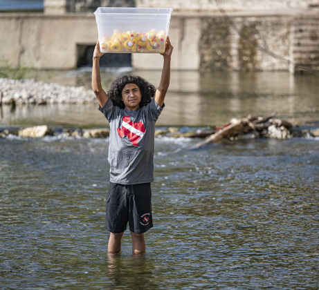13-year-old Xavi Felix gets ready to launch rubber ducks into the water during  the 10th Annual AAUW Duck Race held on the river at San Gabriel Park on Saturday, November 1, 2025.  Rubber ducks are placed in the river and race to the finish in several heats.  Winners of winning ducks win prizes.   The event raises funds for area high school student scholarships. Photo by Andy Sharp.