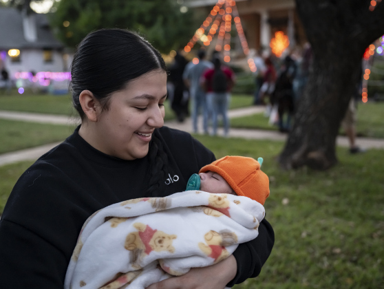 6-week-old Emiliano Marin, enjoying an evening nap,  is held by his aunt Janet Benitez during Halloween along Main Street on Friday, October 31, 2025.  Photo by Andy Sharp.