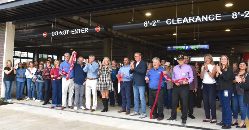 The ribbon cutters, from left, City Manager David Morgan, Council members Kevin Pitts, Ben Stewart, Amanda Parr, Jake French, Shawn Hood, Ron Garland and Ben Butler, celebrated the opening of the garage with city staff and employees from WGI and Swinerton, who helped build the garage. (Photo by Kaitlyn Wilkes)