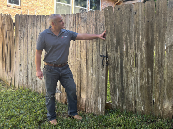 First Responding Home Inspections founder Ross Black, a former Georgetown firefighter, inspects a fence in a client’s backyard.