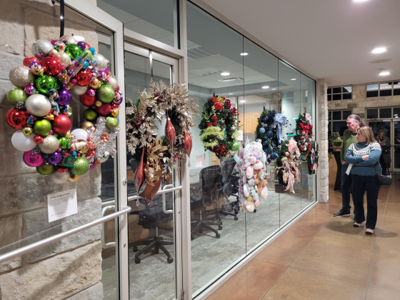 Spectators survey the holiday wreaths up for auction. About 30 wreaths were donated from community members to help raise funds for The Georgetown Project. Photo by Nalani Nuylan.