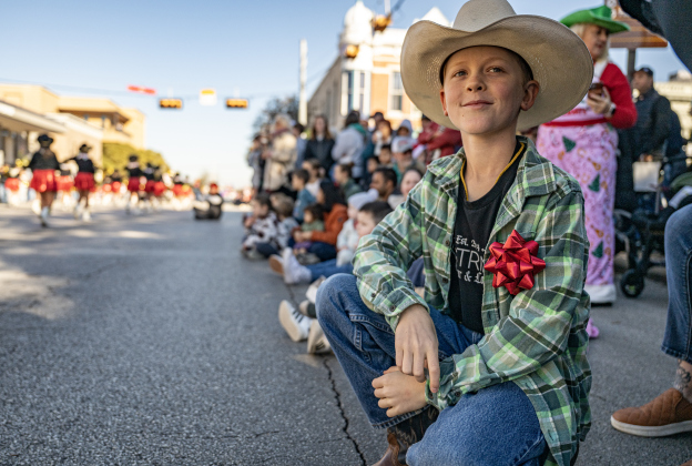 Max Fomichev, 10, had a good place to watch the parade along Austin Avenue during the annual Christmas Stroll, held in downtown Georgetown on Saturday, December 6, 2025.   Photo by Andy Sharp.