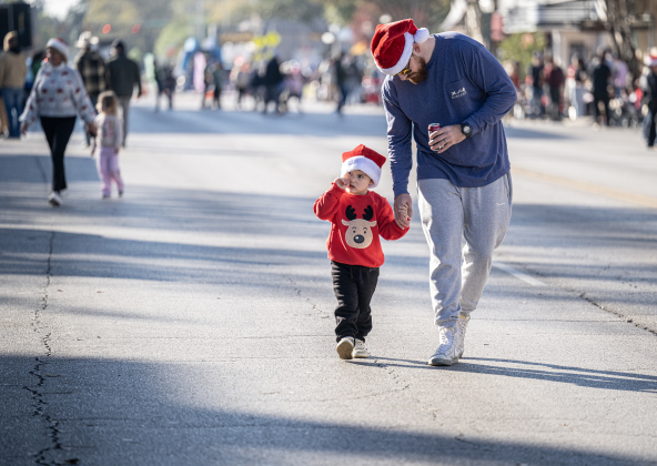 Curry Wyman and his son Hezy, 3, take a walk  Austin Avenue before the parade starts during the annual Christmas Stroll, held in downtown Georgetown on Saturday, December 6, 2025.   Photo by Andy Sharp.
