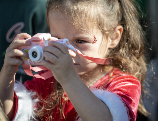 3-year-old Henlee Eaton brought her own camera (it really is a working camera)  to take photographs of the parade along Austin Avenue during the annual Christmas Stroll, held in downtown Georgetown on Saturday, December 6, 2025.   Photo by Andy Sharp.