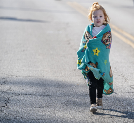 4-year-old Jaylie Brinker used a blanket to hold back the morning chill as she walked along Main Street with her grandfather David Parma  during the annual Christmas Stroll, held in downtown Georgetown on Saturday, December 6, 2025.   Photo by Andy Sharp.