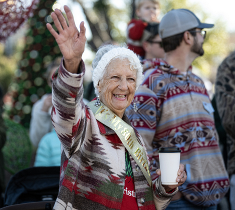 Cynthia McCoy, wearing a sash honoring her 80th birthday on Friday, enjoyed watching the parade along Austin Avenue during the annual Christmas Stroll, held in downtown Georgetown on Saturday, December 6, 2025.   Photo by Andy Sharp.