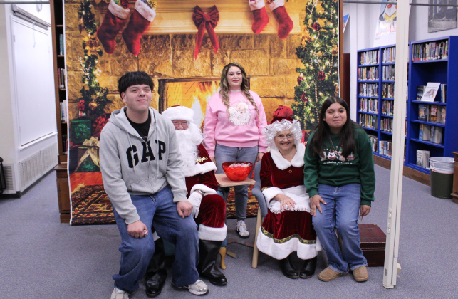 Two Florence High school siblings are joined by their mother to take a photo with Mr. and Ms. Clause, proving your not too old for Christmas.