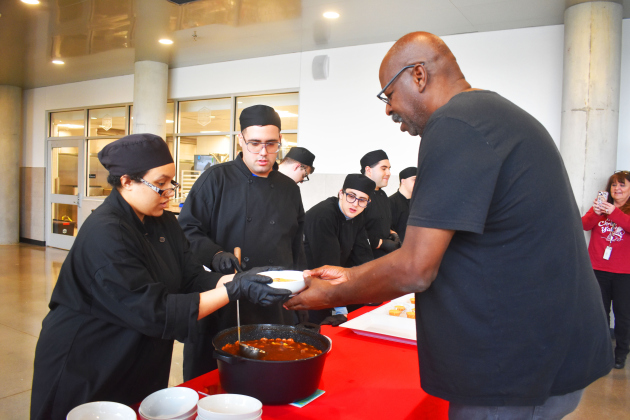Enjoying beef stew is diner Chuck Collins, executive director of GTX Connect. Luncheon chefs were students in GISD’s Bridges program at GISD’s Future Ready Complex. From left, are Bridges graduate and now instructor Tyanna Eiland; and students Gabriel Romero-Miro, Peyton Martin, Derek Fried, Mathew Ayala and Lucas Davenport.