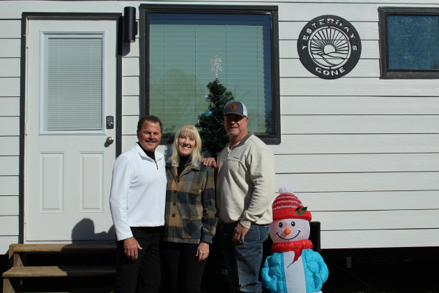 Donors Glenda and Ron Johnston, left, and builder Chad Moore, right, celebrate the unveiling of the latest tiny home on the Yesterday’s Gone property, December 19. Photo by Nalani Nuylan.