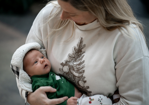 Kate Hill cuddles her 11-day-old son Oliver during the Lighting of the Square on Friday, November 28, 2025.   Photo by Andy Sharp.