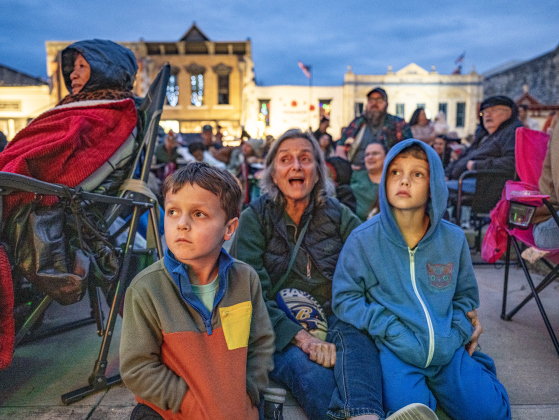 Tyler Dey, 5, left, and his brother Julian, 8, right, were joined by their grandmother Judy Schwarz, center,  during the Lighting of the Square on Friday, November 28, 2025.  Photo by Andy Sharp.