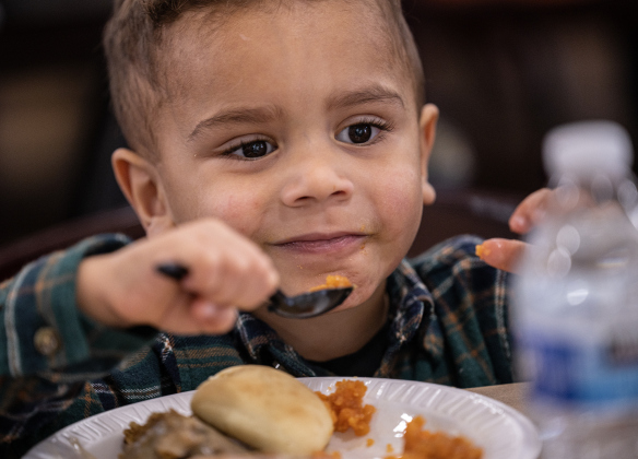2-year-old Christian Santiago enjoys his meal during the Georgetown Community Thanksgiving, held at the San Gabriel Community Center on Thursday, November 27, 2025.