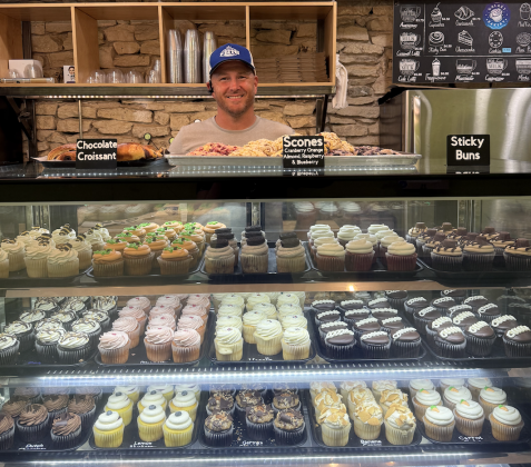 The owner of Galaxy Bakery, Ike Thorpe, stands behind the counter with his cupcakes. Photo by Abbey Archer