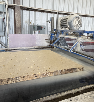 A surfacing line uses a drum polisher with industrial diamonds to gauge thickness and put a finish on flat limestone panels.