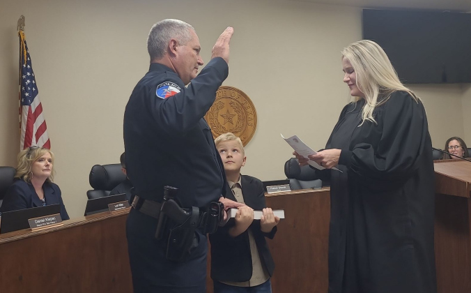 Jim McLean, left, is sworn in by his wife, Justice of the Peace Evelyn McLean of Precinct 3, right, as the City of Jarrell’s new Chief of Police on January 6 at City Hall. Photo by Nalani Nuylan.