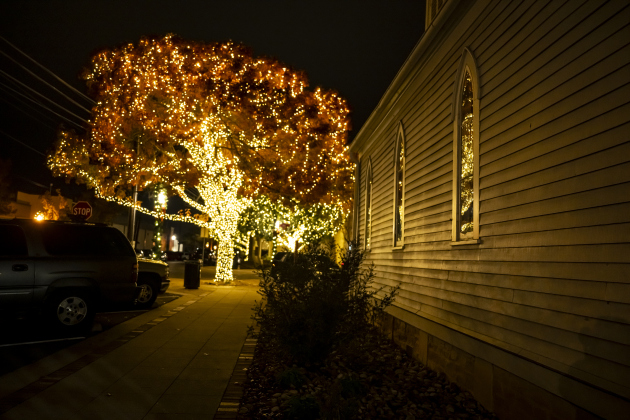 Lights from a nearby tree fall on the facade of Grace Heritage Center  on Tuesday, December 16, 2025.  Seasonal lights are abundant in Downtown Georgetown this year.  Photo by Andy Sharp.