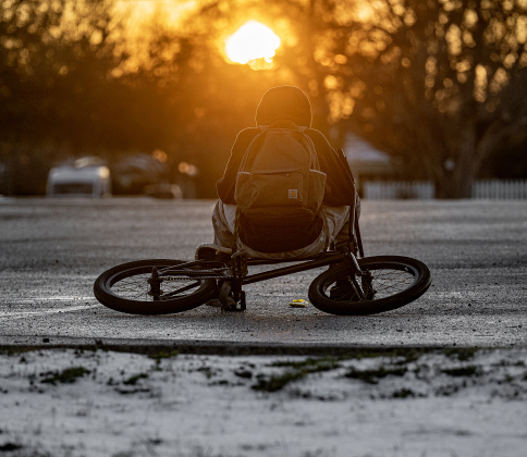 A bicyclist takes a rest break in a parking lot at Murphy Park  as sunset nears on an icy Monday afternoon, January 26, 2026.  The temperature reached the low-mid 30s Monday, and dipped into the teens overnight.  Photo by Andy Sharp.