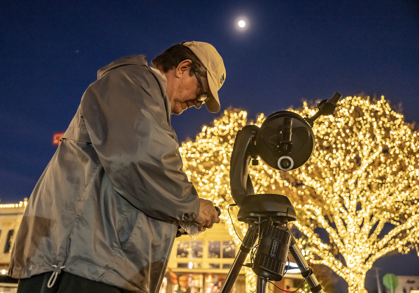 Brad Sloan sets up his telescope at 8th and Main Streets  for visitors to the Georgetown square to see an upclose view of the Waxing Gibbous moon, at 92.3% visibility on Wednesday, December 31, 2025, New Years Eve in Georgetown.   Photo by Andy Sharp.