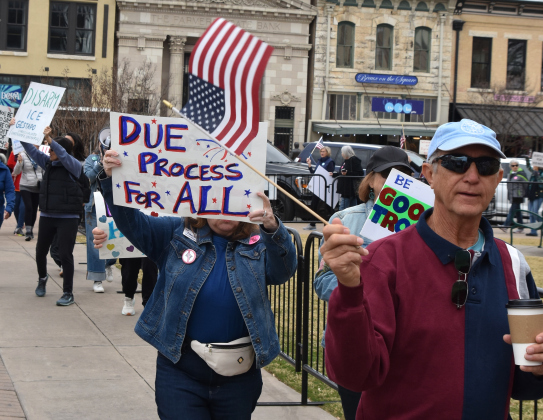 Many protestors waved small American flags as they walked around the Williamson County Courthouse in downtown Georgetown on January 20. (Photo by Kaitlyn Wilkes)