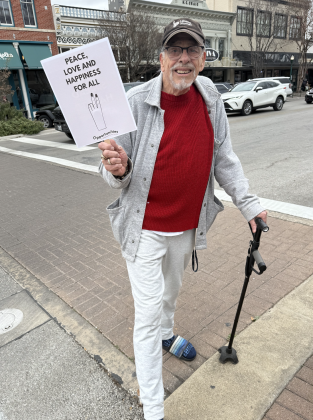Drew Gautreaux, who is in hospice with lung cancer, marched holding a sign and using his cane for assistance. (Photo by Abbey Archer)