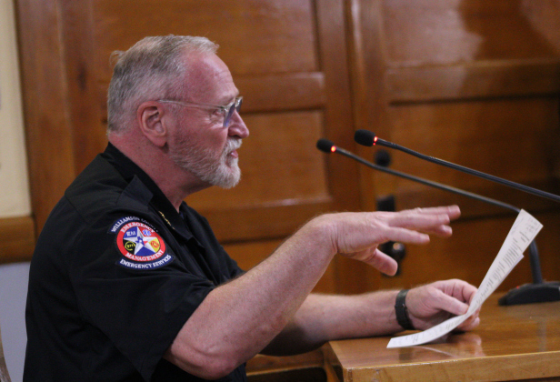 Bruce Clements, director of emergency management for Wilco, explains the flood resource grant from the Texas Water Development Board during the February 10 Commissioners Court meeting. Photo by Nalani Nuylan.