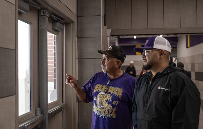 Granger ISD staffer Daniel Perez, left, visits with Ricky Luna, parent of a Granger student, as they talk about the new Granger Secondary School during an open house on Wednesday, February 25, 2026.  They’re looking out onto a courtyard where students and staff can gather outdoors. Photo by Andy Sharp