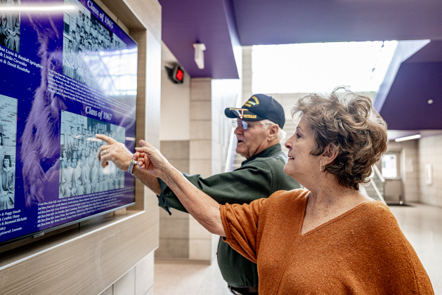 Cliff Marek and his wife Janis look at a display of older photos near the entrance to  the new Granger Secondary School during an open house on Wednesday, February 25, 2026.