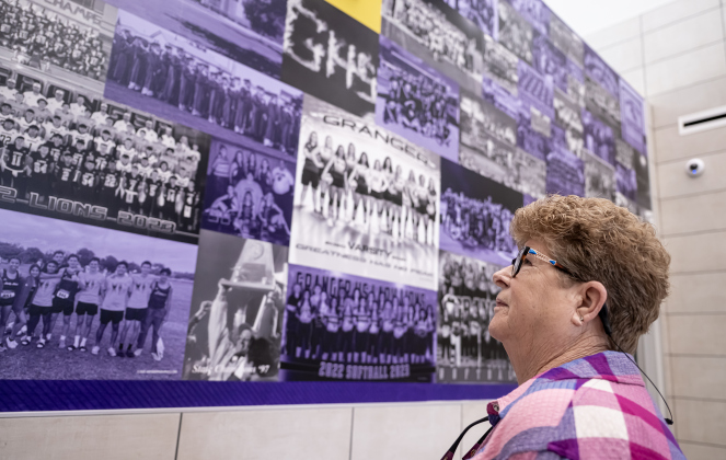 Visitor Mary Pavlat looks over a display of vintage school photographs  on display near the entrance of  the new Granger Secondary School during an open house on Wednesday, February 25, 2026.