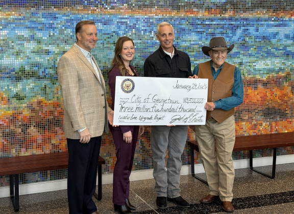 Williamson County Judge Steve Snell, State Rep. Caroline Harris Davila, Georgetown Mayor Josh Schroeder, and U.S. Rep. John Carter pose with a check for $3.5 million.