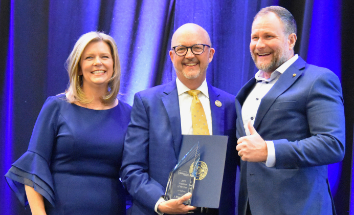 J. Brad Curlee, center, accepts the award for Volunteer of the Year. He was joined by last year’s winner, Andy Webb, right, and chamber president Shontel Mays, left.