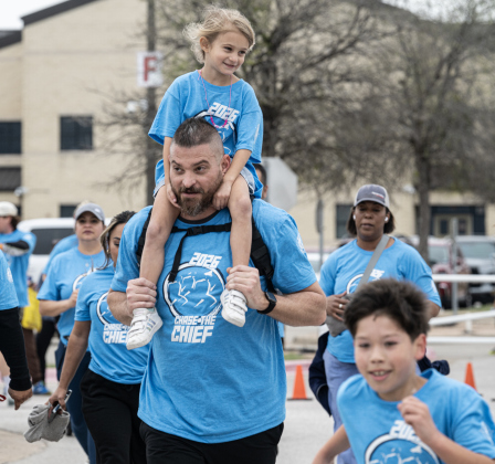 Corey Ormsby, carrying daughter Lyla, 4, on his shoulders, nears the finish line in the Fun Run during the annual Chase The Chief races held at East View High School on Sunday, March 8, 2026.