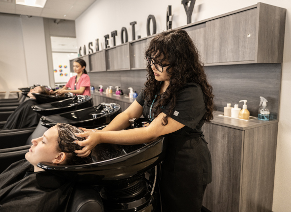 East View High cosmetology student Valeria Velazquez shampoos the hair of  Ashlyn Schampers, a cosmetology student from Georgetown High,  while behind them cosmetology student Analeah Valero from Georgetown High shampoos the hair of fellow Georgetown High student Juliet Aldridge  at the Georgetown ISD State of the District gathering held at the Future Ready Complex on Friday, March 6, 2026.