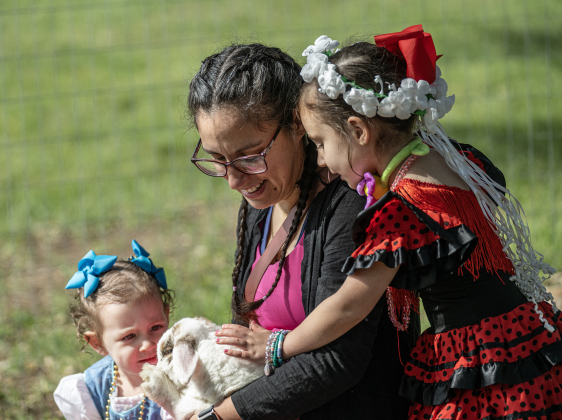 Kristyna Bell and her daughters Marilyn, 2, left, and Lydia, 4, right, spend time with a lop-eared rabbit in the petting zoo area at the Old Settlers Association  site during The Williamson Museum’s Hoppy Easter event on Saturday, March 14, 2026.    Photo by  Andy Sharp. 