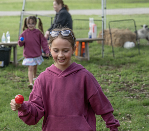 8-year-old Delilah Taylor, front, and her sister Joanna, 6, back left, practice walking while balancing Easter eggs  at the Old Settlers Association  site during The Williamson Museum’s Hoppy Easter event on Saturday, March 14, 2026.