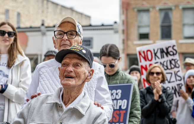World War II Navy veteran Cliff McCrummen, who will be 100-years-old in June, was joined by his wife Myrna at the No Kings rally held in downtown Georgetown on Saturday, March 28, 2026.  Approximately 700 people attended the rally, a demonstration opposed to the current Presidential administration of Donald Trump.  Photo by  Andy Sharp. 