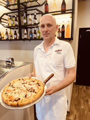 Frankie’s Pizza and Pasta Manager Jeff Metalia holds a fresh pie in his renovated restaurant.