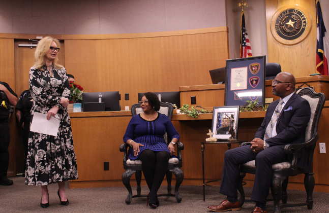 Hosted by Judge Donna King of the 26th District Court (left), Mr. Miller and his wife, Amanda (center), listen to Judge King’s speech.