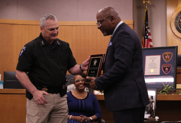 Chief Deputy Randy Trailer of the Sheriff’s Office (left) presents a plaque of honor to Mr. Miller for his 30 years of service.
