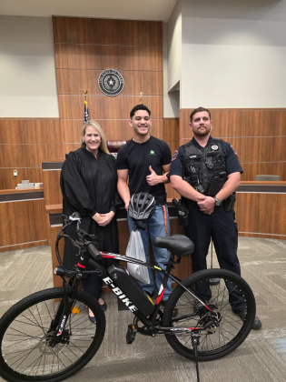 Sixteen-year-old Kevin Rodriguez, center, received a bike after meeting Judge Evelyn McLean and Deputy Constable Adam Hughes at the Justice Court Precinct Three courtroom February 18. Photo courtesy of Evelyn McLean.
