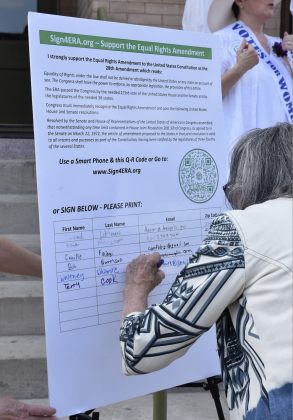 After speaking about the importance of the Equal Rights Amendment, Commissioner Terry Cook signed a large version of the petition.