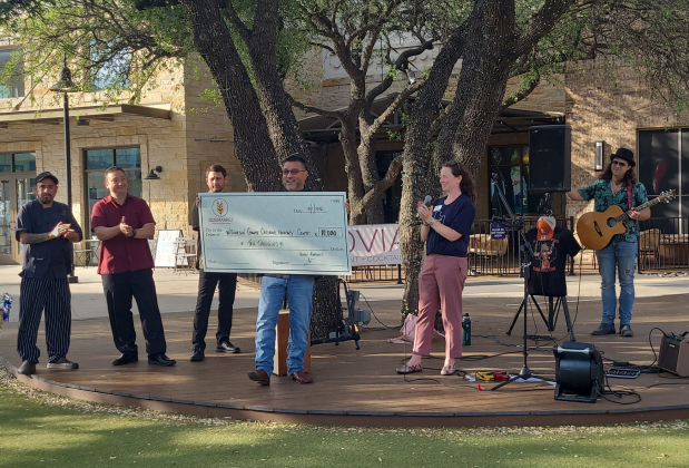 Tiffany Sturman, chief advancement officer for the Williamson County Children’s Advocacy Center (right), accepts a $10,000 check from 2020 Market Scratch Kitchen &amp; Bar, April 1. Photo by Nalani Nuylan.