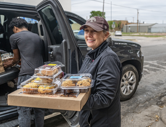 Volunteer April Vega helps distribute food items to a recipient at Shepherd’s Heart Food Pantry on Saturday, March 28, 2026.  Shepherd’s Heart Food Pantry and Thrift Shop, at 121 East 2nd Street, was founded by Executive Director Loretta Masters in 1994.  The group distributes food several times a week.  In 2025 Shepherd’s Heart averaged 2,110 distributions a month.    Photo by  Andy Sharp.