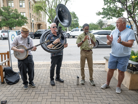 Tom Bowman, right, claps to the music of Swing Shift, including (left to right) Johnny Serrano (banjo), Bill Troiano (Sousaphone) and Luke Allen (trumpet) during the Art Stroll on Friday, April 17, 2026.