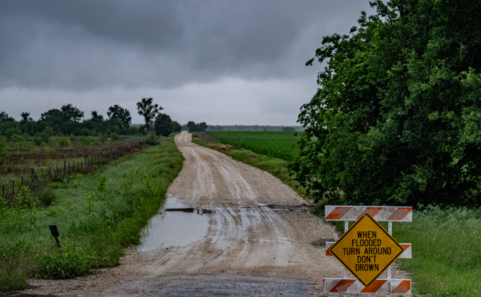 A sign warns motorists to avoid County Road 349 east of Granger  on Tuesday, April 21, 2026. This road borders a portion of Granger Lake.   Rain was present throughout the day in Williamson County, closing some of the area’s roads.      Photo by  Andy Sharp.