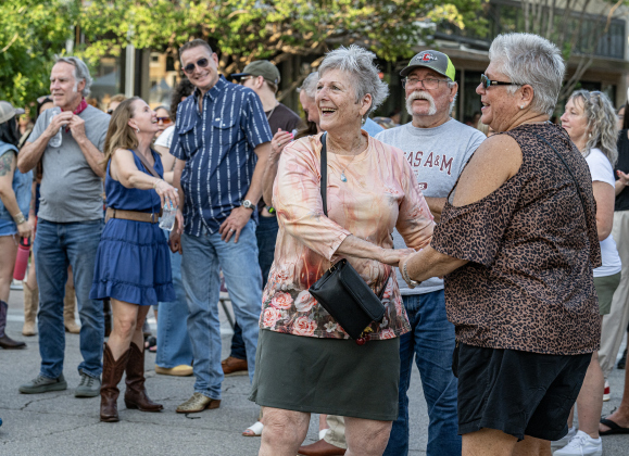 Jayne Cherry, left, dances with her daughter Gail Hendry as they enjoy the music of Red-Eyed Gambler on Friday, April 24, 2026, the first night of the Red Poppy Festival. Jayne’s grandson Beaux Cherry is a member of the group.      Photo by  Andy Sharp.