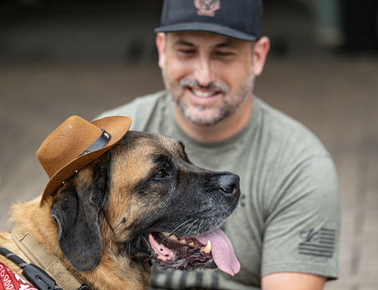 Doogie, a 120-pound Mastiff/St. Bernard mix who likes his  cowboy hat, waits with his human Mike Newman for the start of the Red Poppy Festival parade on Saturday, April 25, 2026.   Photo by  Andy Sharp.