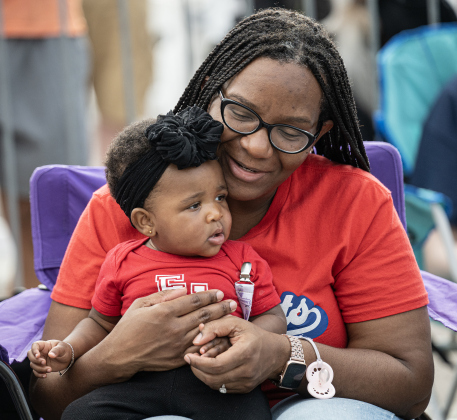 Karhenda Johnson and her 9-month-old daughter Myla were there to watch Myla’s brother, a member of the East View High football team, take part in  the Red Poppy Festival parade on Saturday, April 25, 2026.   Photo by  Andy Sharp.